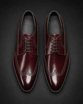 Top-down view of a bespoke burgundy Derby pair showing full-brogue pattern and TBS insole mark